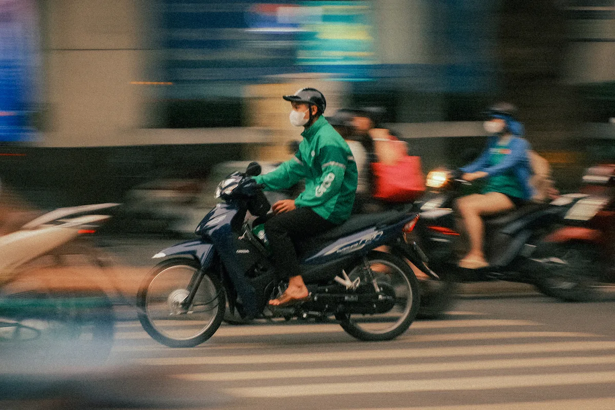 Người lái xe máy đội mũ bảo hiểm di chuyển trên đường phố