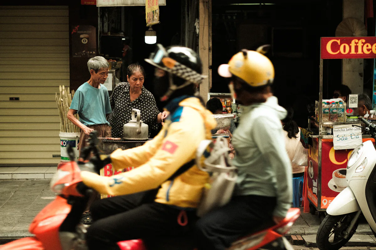 Hai người đội mũ bảo hiểm ngồi trên xe máy màu đỏ trong phố