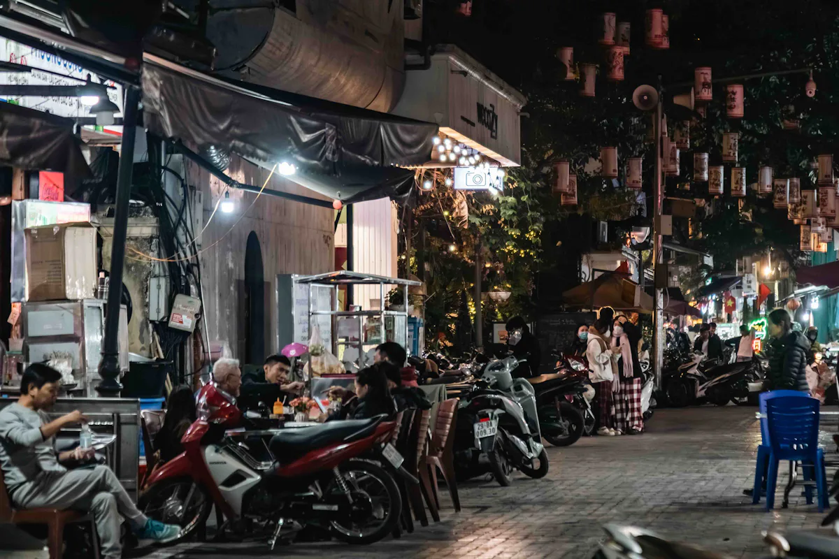Xe máy đỗ bên dãy cửa hàng trong con phố vào buổi tối